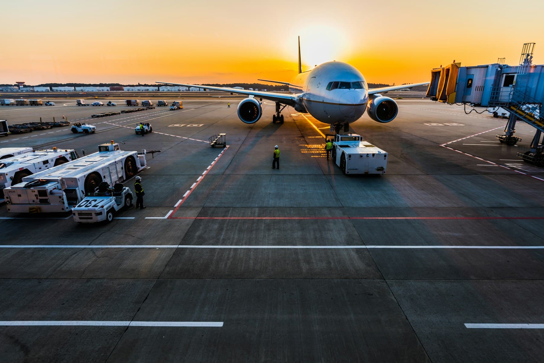 Wide-body freighter aircraft being loaded on the apron at sunset